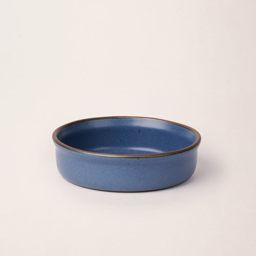 Wide shallow ceramic ramekin in a cool blue color with an unglazed rim