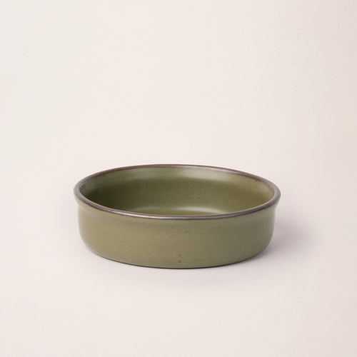 Wide shallow ceramic ramekin in an olive green color with an unglazed rim