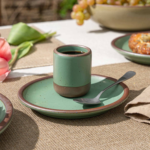 A handleless ceramic cup for small pours in a viridian green glaze with a matte finish.