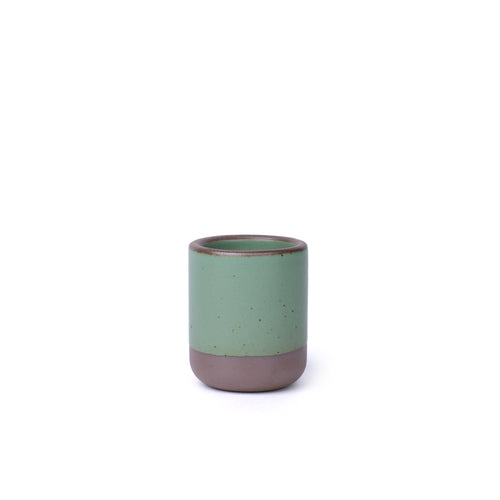 A handleless ceramic cup for small pours in a viridian green glaze with a matte finish.
