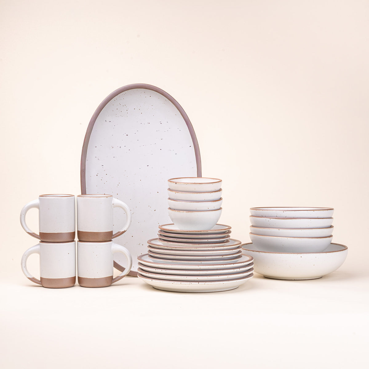 A 26-piece tablesetting with four mugs, four cake plates, four side plates, four dinner plates, 4 shallow bowls, 4 ice cream bowls, a large shallow bowl and an oval platter in a cool white color
