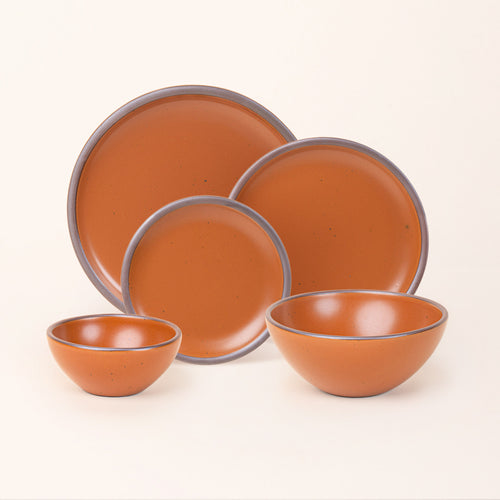 An ice cream bowl, soup bowl, cake plate, side plate and dinner plate paired together in an earthy orange color featuring iron speckles