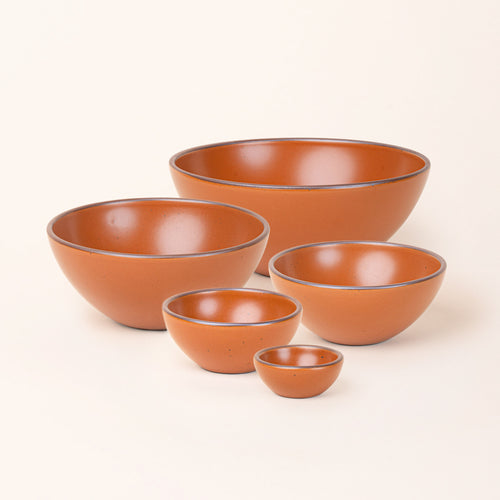 A bitty bowl, ice cream bowl, soup bowl, popcorn bowl, and mixing bowl paired together in an earthy orange color featuring iron speckles