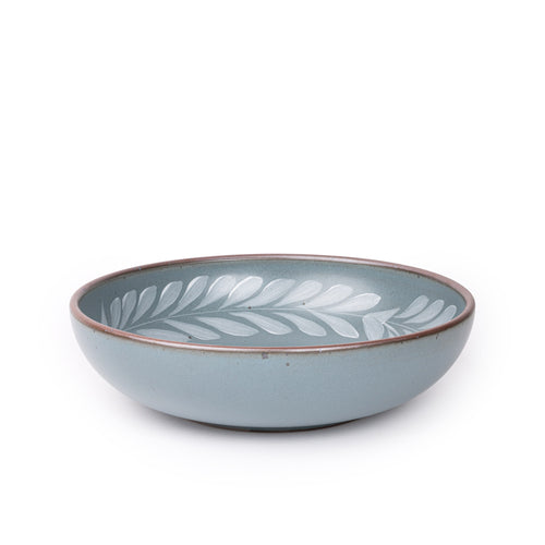 Large ceramic shallow bowl with a hand-painted white leaf border on a blue-grey interior and exterior with an exposed clay rim.