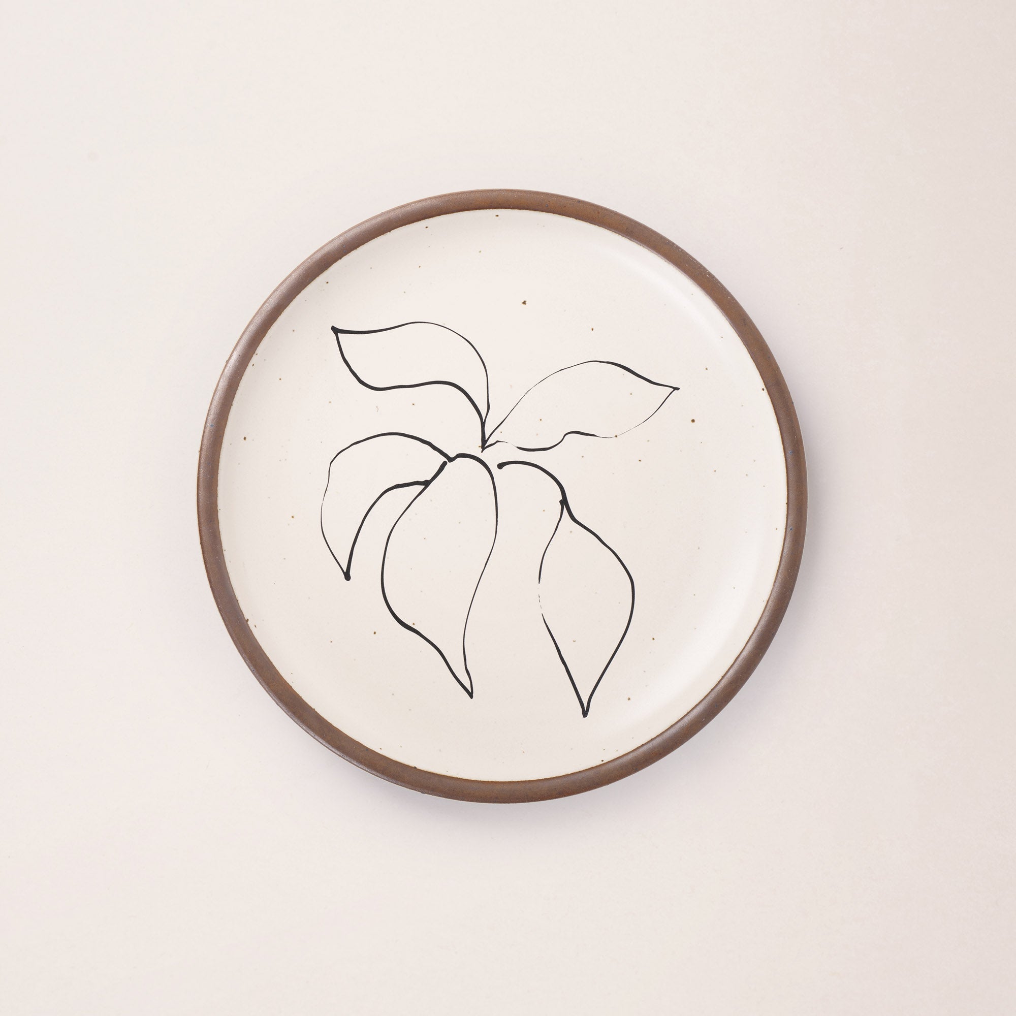 A warm off-white ceramic dinner plate featuring a black Verve illustration by Henri Matisse.