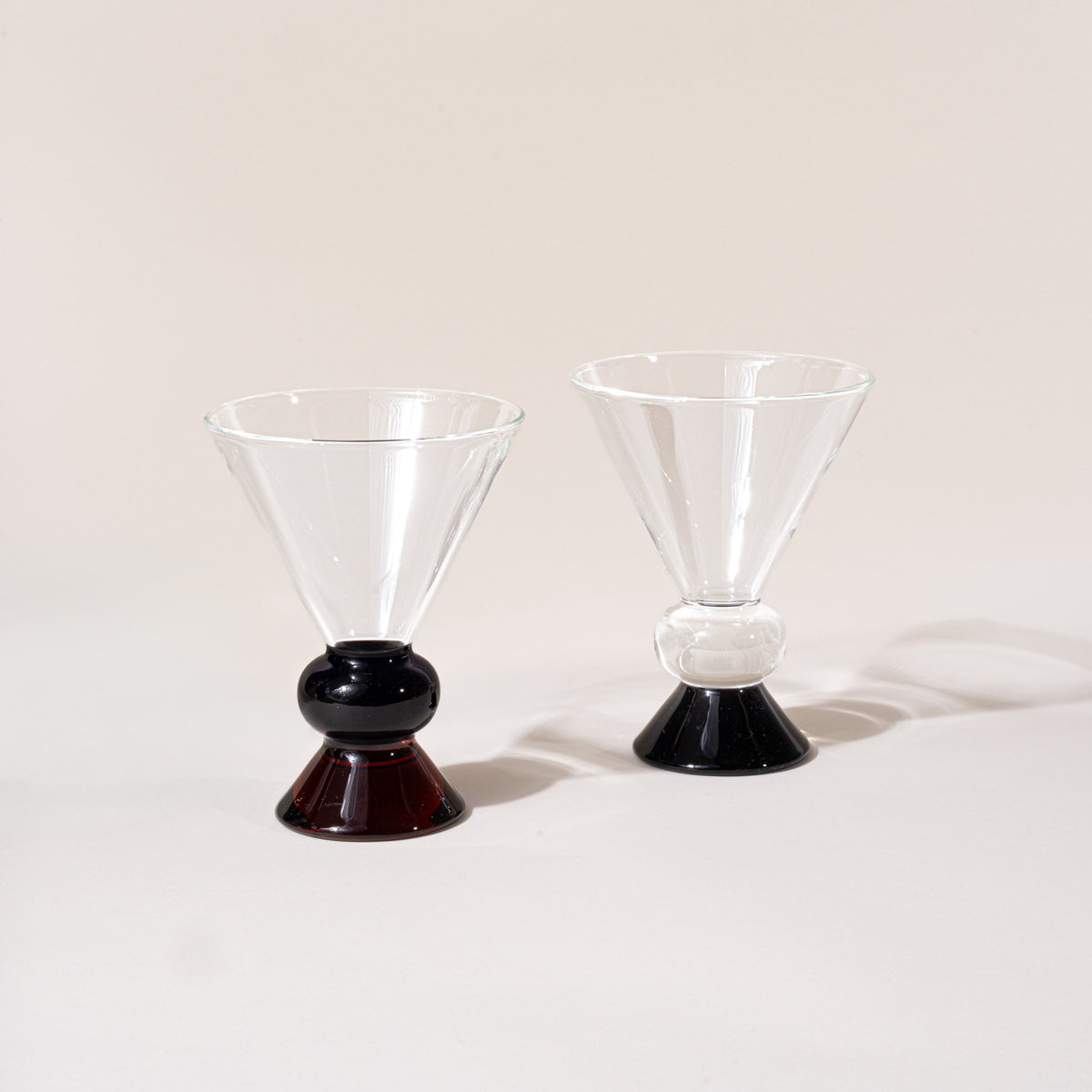 Two clear cocktail-style glasses with sculptural clear, blue and amber base.