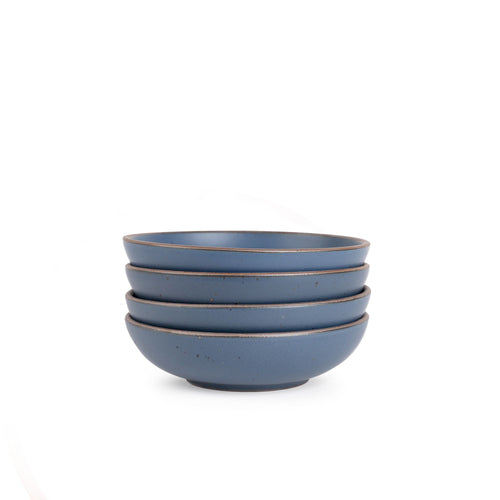 A stack of 4 dinner-sized shallow ceramic bowls in a cool, medium blue color featuring iron speckles and an unglazed rim