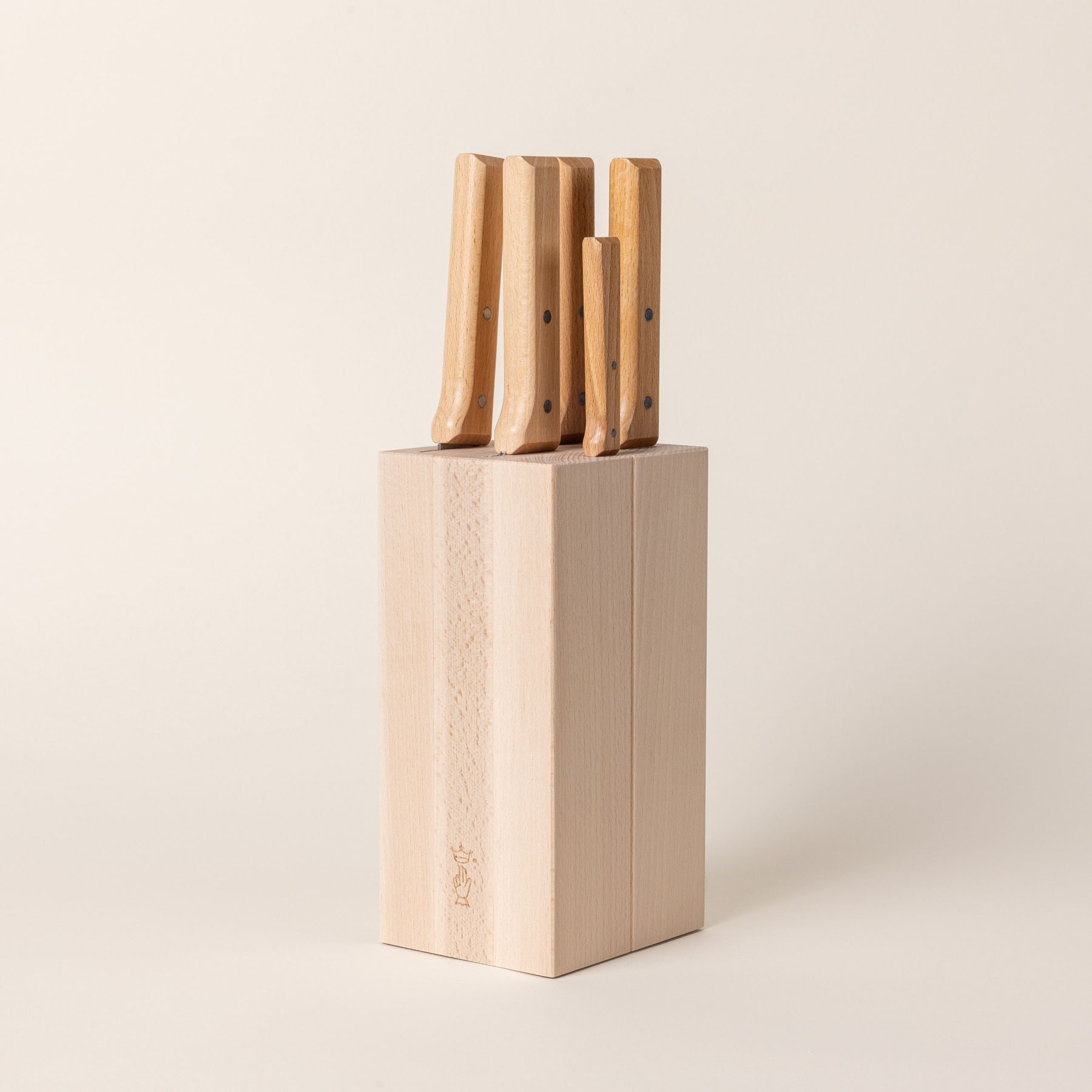 A tall rectangular wooden block with knives inside and the wooden handles sticking out at the top.