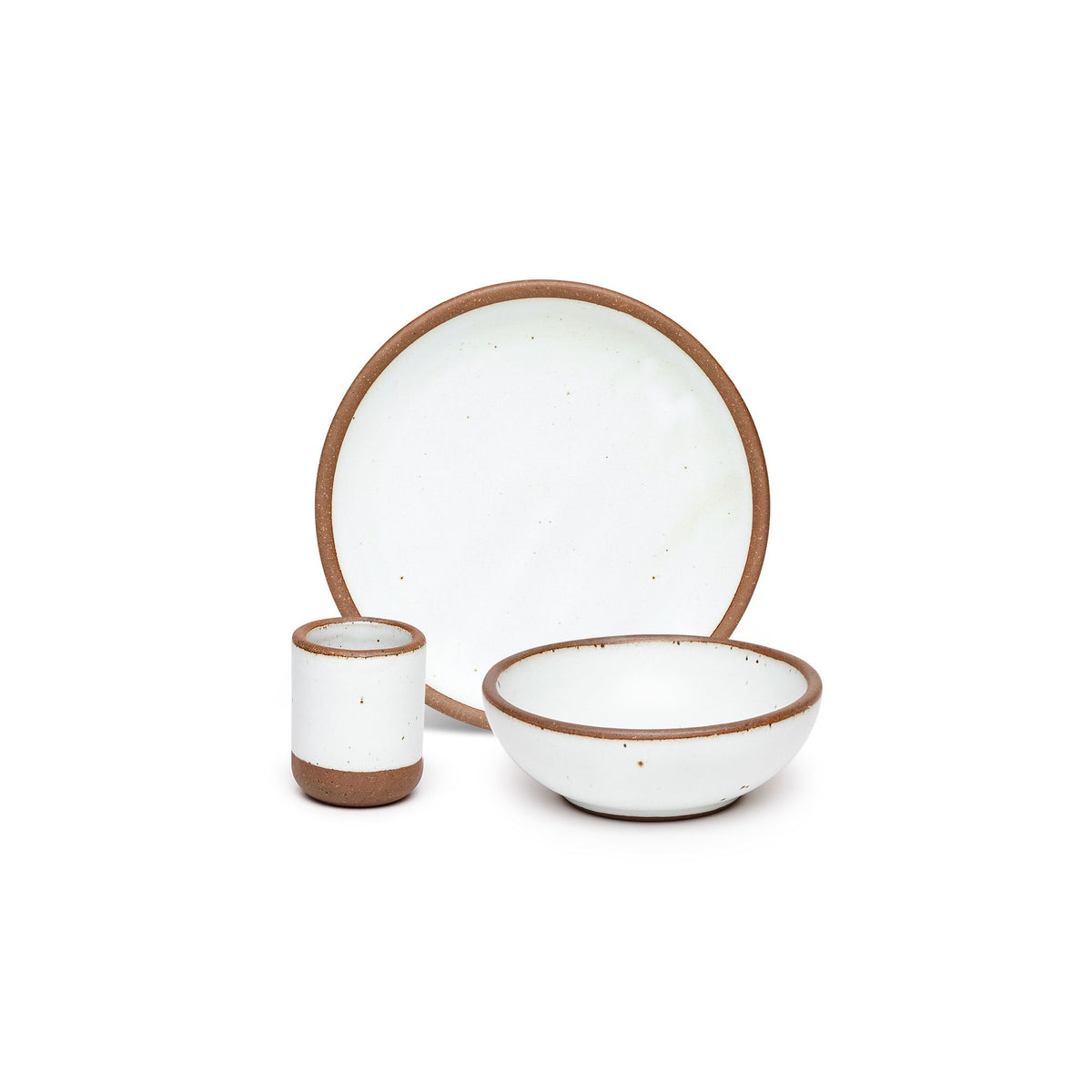 A small tiny cup, a medium sized plate, and a small breakfast bowl paired together in a cool white color featuring iron speckles.