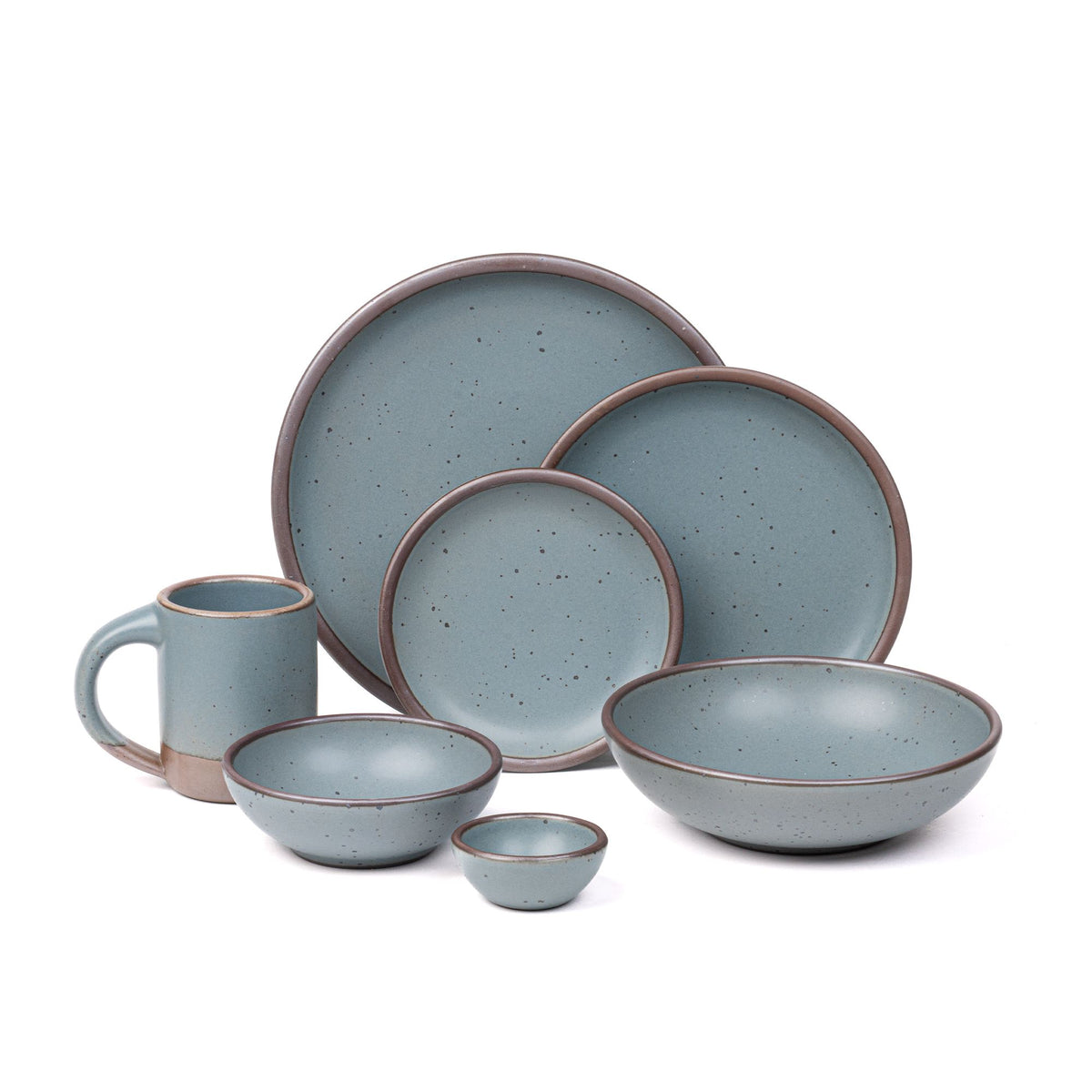 The Mug, bitty bowl, breakfast bowl, everyday bowl, cake plate, side plate and dinner plate in a blue-grey color featuring iron speckles