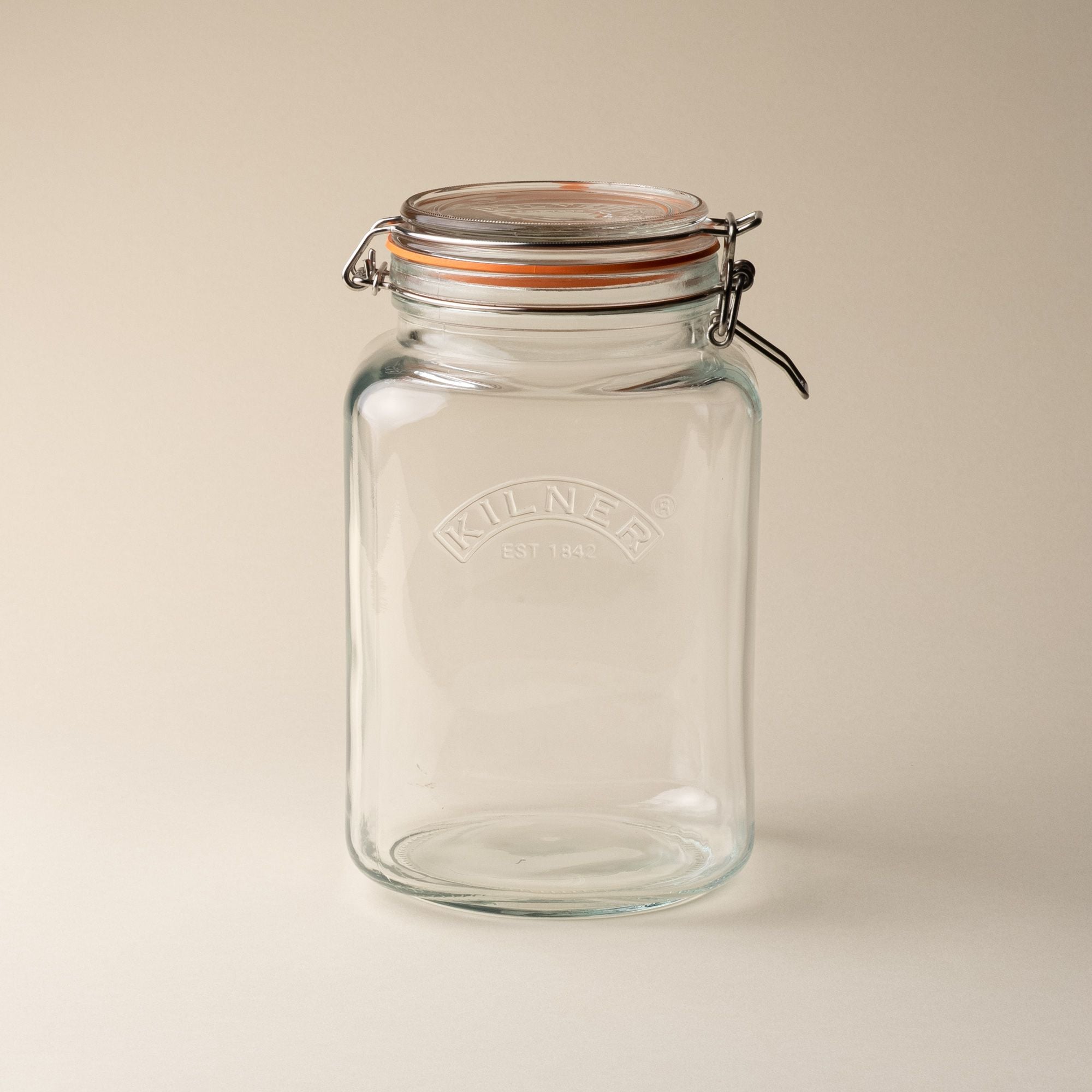 A large storage glass square jar topped with a lid with a rubber seal and steel clip closure.