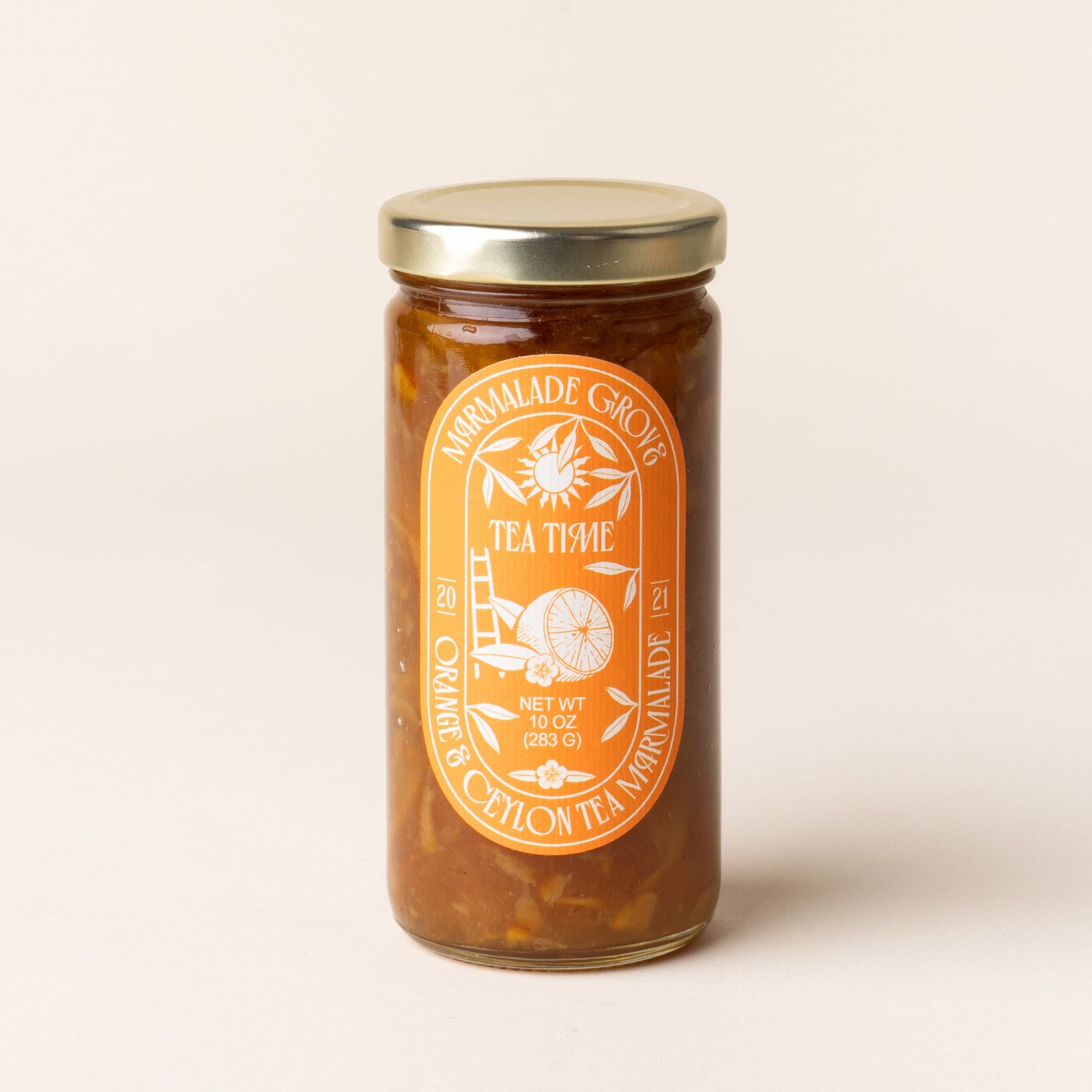 A jar of Marmalade Grove Orange & Ceylon Tea Marmalade, with a bright orange label featuring citrus and floral illustrations.