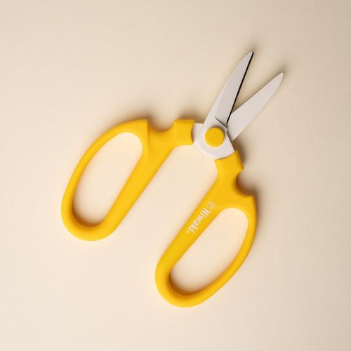 An open pair of flower scissors with large yellow handles and short blades.