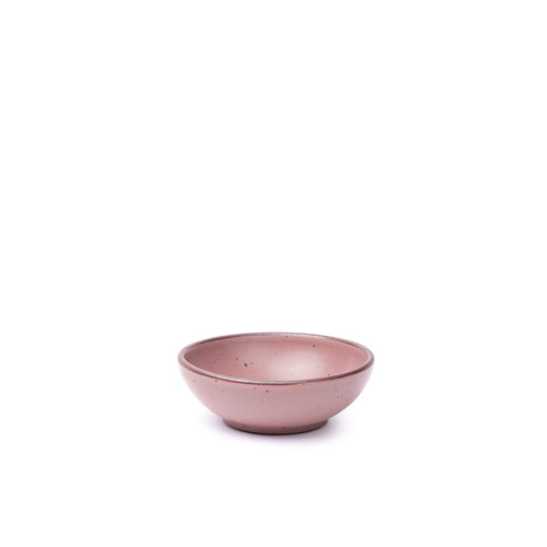 A small shallow ceramic bowl in a dusty mauve pink color featuring iron speckles and an unglazed rim