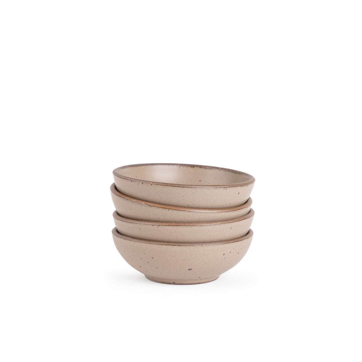 A stack of 4 small shallow ceramic bowls in a warm pale brown color featuring iron speckles and an unglazed rim
