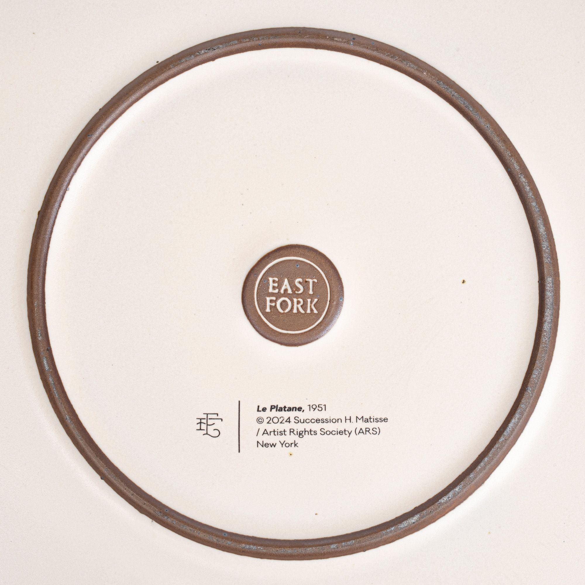 The back of the Serving Platter with an East Fork stamp with a small decal of information about the artwork.