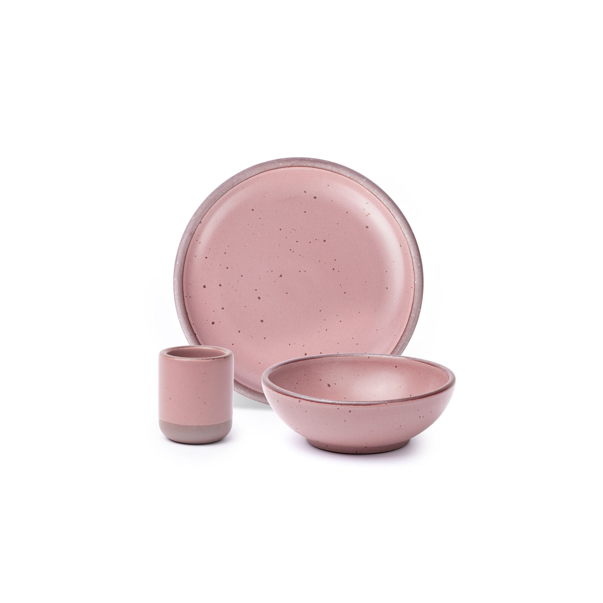 A small tiny cup, a medium sized plate, and a small breakfast bowl paired together in a dusty mauve pink color featuring iron speckles