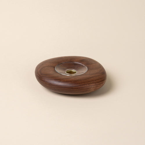 Large round walnut wood candle holder with visible grain and a glass insert in the center, displayed against a neutral background.