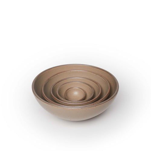 A bitty bowl, ice cream bowl, soup bowl, popcorn bowl, and mixing bowl paired together in a warm pale brown color featuring iron speckles, nesting inside each other