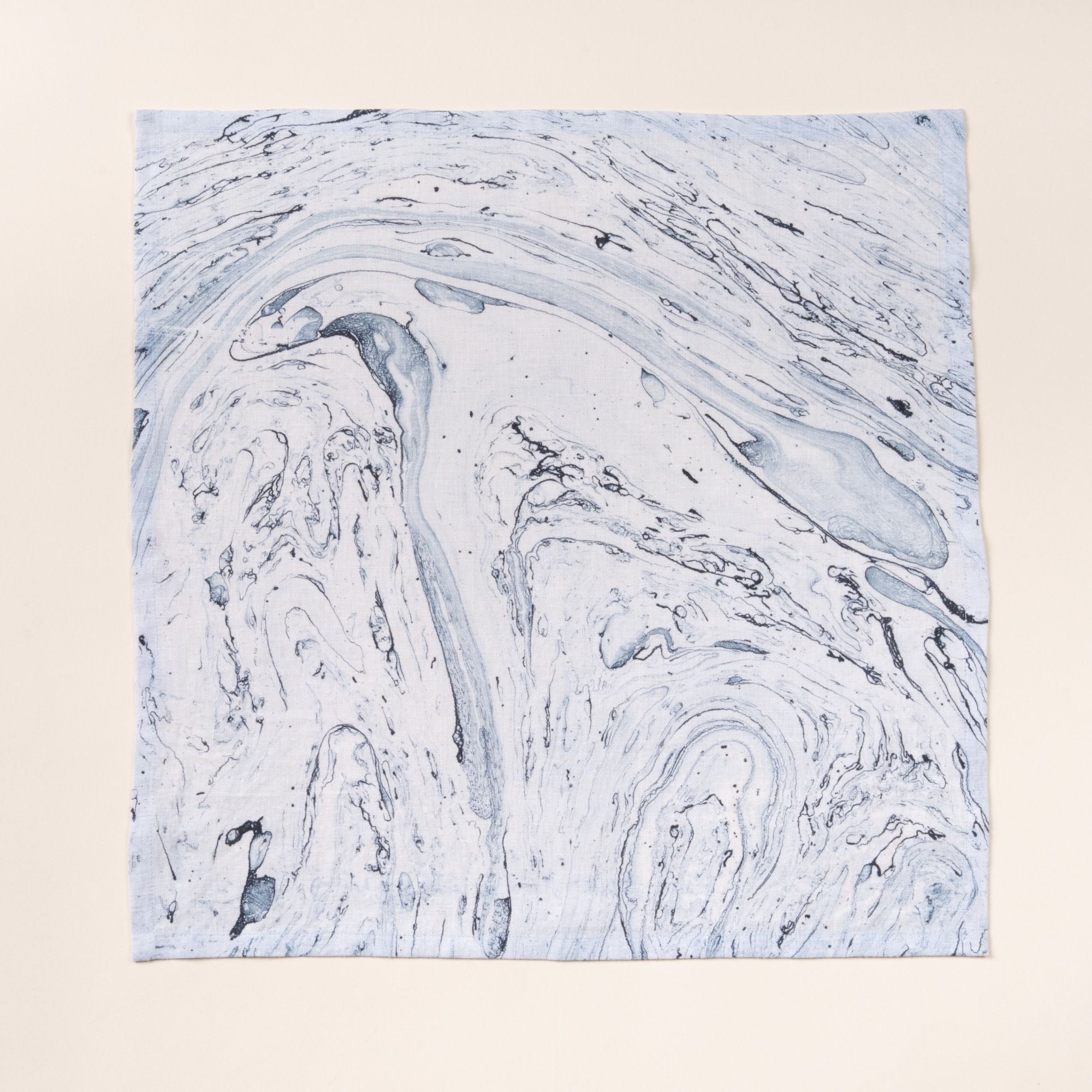 Blue marbled cloth napkin with swirling stone-like pattern on a light background.