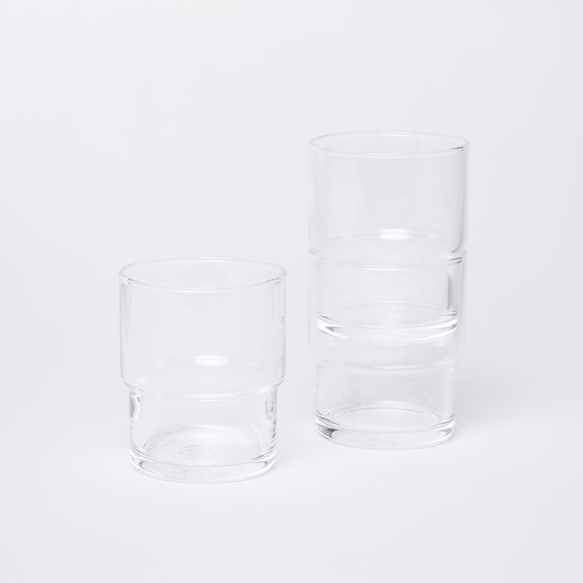 One glass on the left next to two stacked glasses on the right