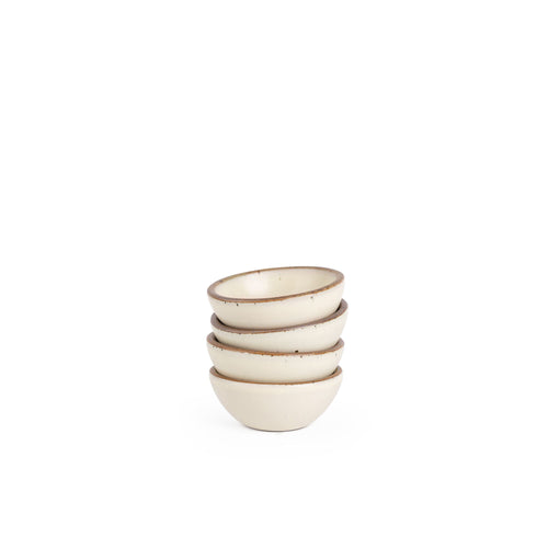 A stack of 4 tiny rounded ceramic bowls in a warm, tan-toned, off-white color featuring iron speckles and an unglazed rim