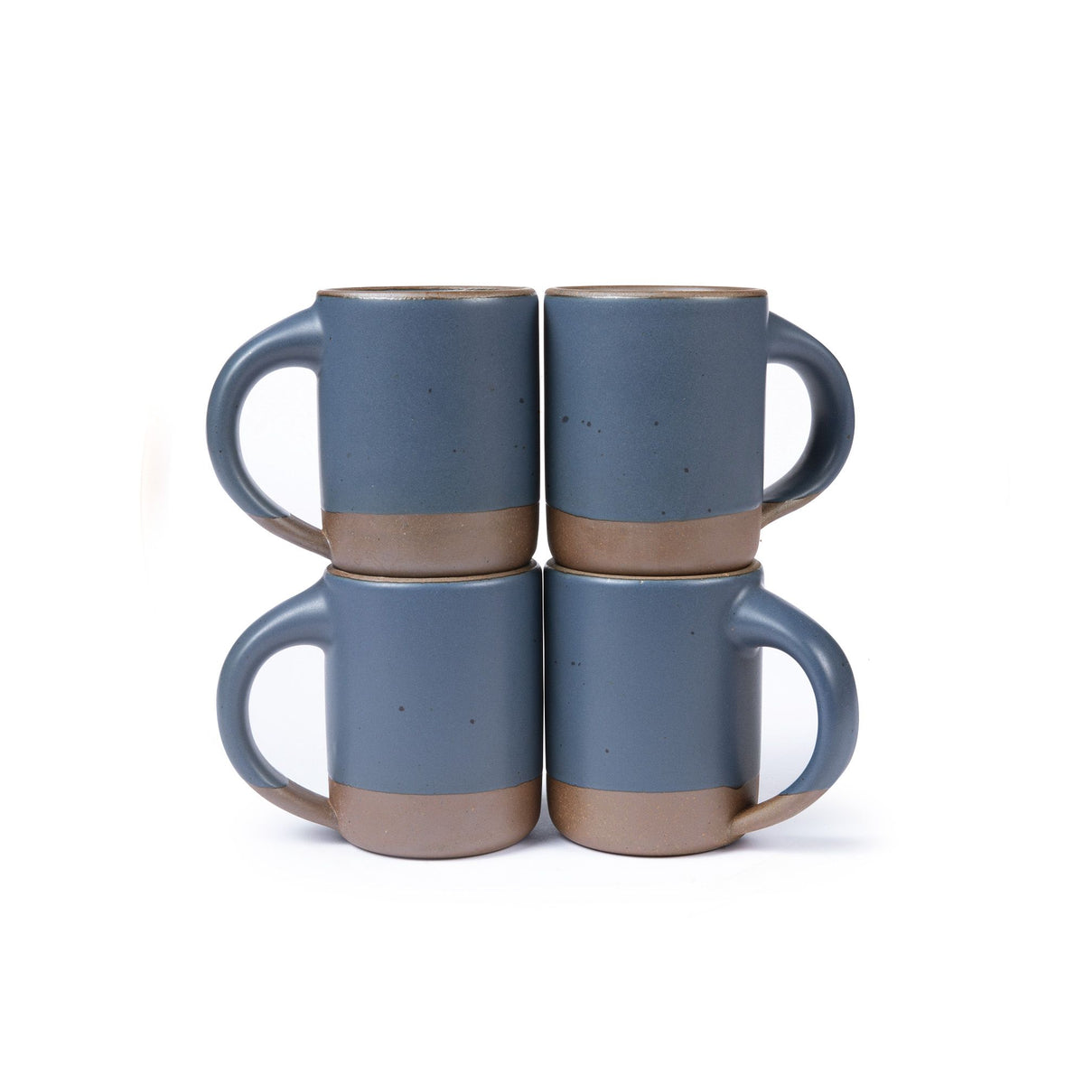 Four medium sized ceramic mugs with handles in a cool medium blue color featuring iron speckles and unglazed rim and bottom base, stacked in sets of 2.