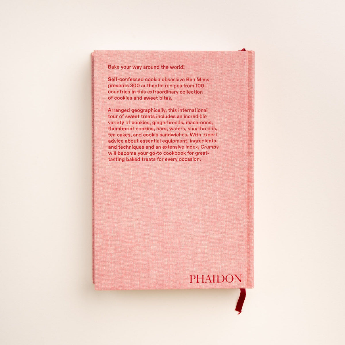 Back cover of 'Crumbs' cookbook with pink cloth design and red text about the author and 300 cookie recipes.