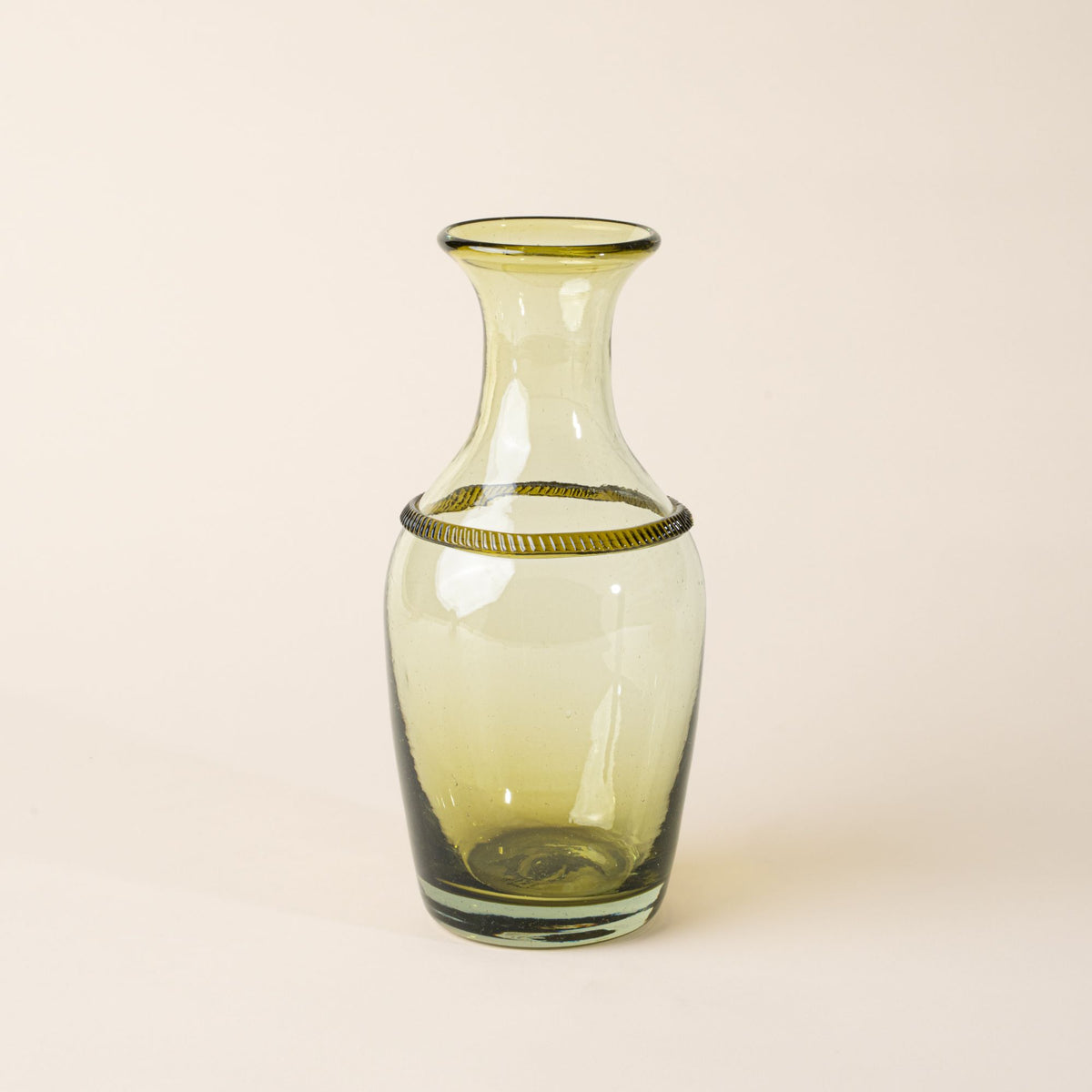 Light green glass bottle vase with a flared neck and decorative ring detail on a neutral background.