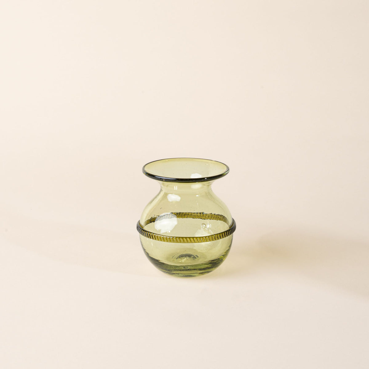 Small light green glass vase with a rounded body, flared rim, and decorative band around the center, displayed on a neutral background.