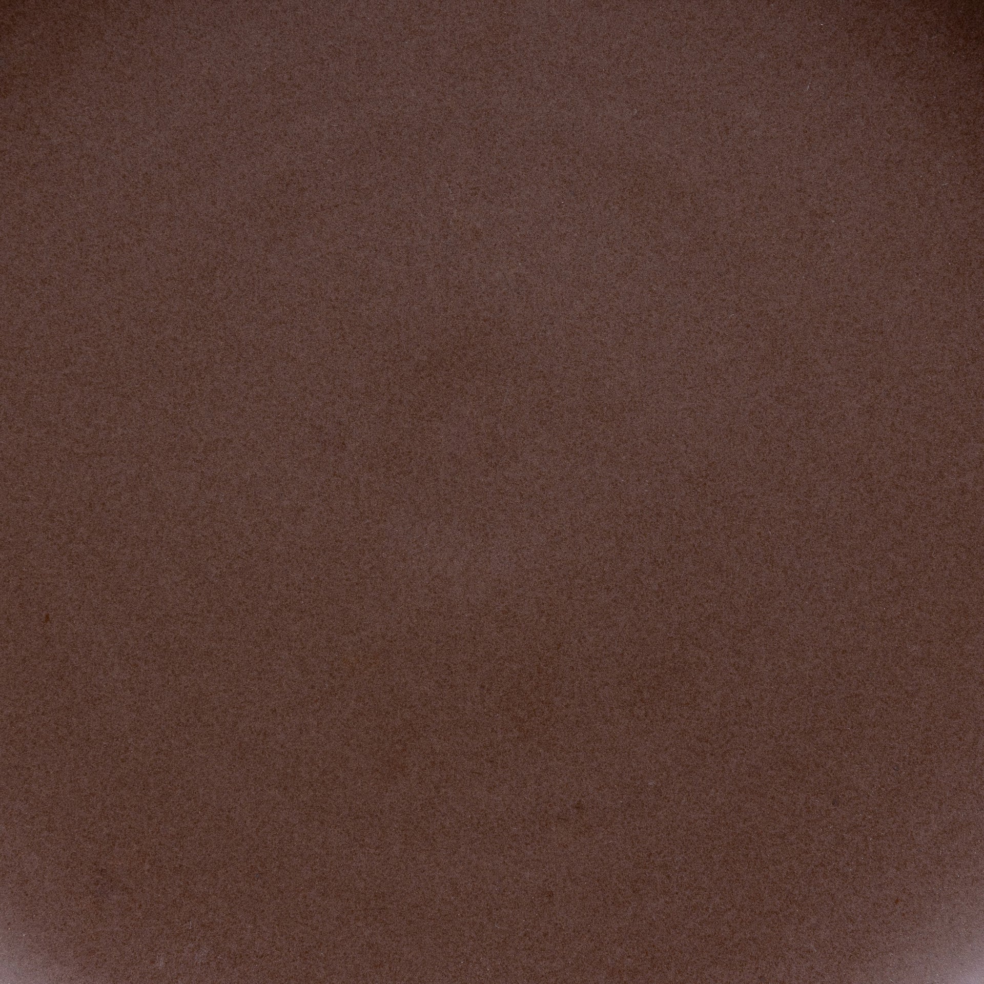 A closeup of a ceramic plate in a dark brown color