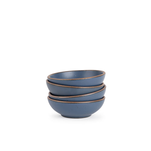 A stack of 4 small shallow ceramic bowls in a cool, medium blue color featuring iron speckles and an unglazed rim