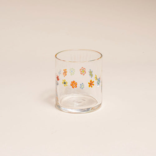 Clear glass with a ring of multicolored little flowers on a cream background.