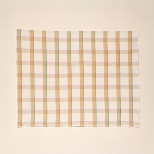 A rectangular plaid placemat with lines of pastel pink, teal, and peach.