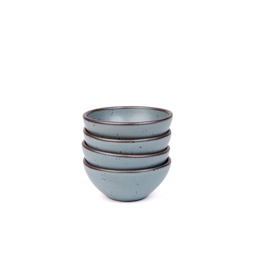 A stack of 4 small dessert sized rounded ceramic bowls in a blue-grey color featuring iron speckles and an unglazed rim