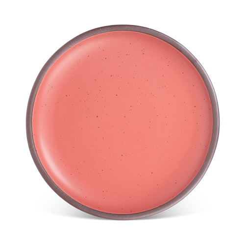 A large ceramic platter in a watermelon pink color featuring iron speckles and an unglazed rim.