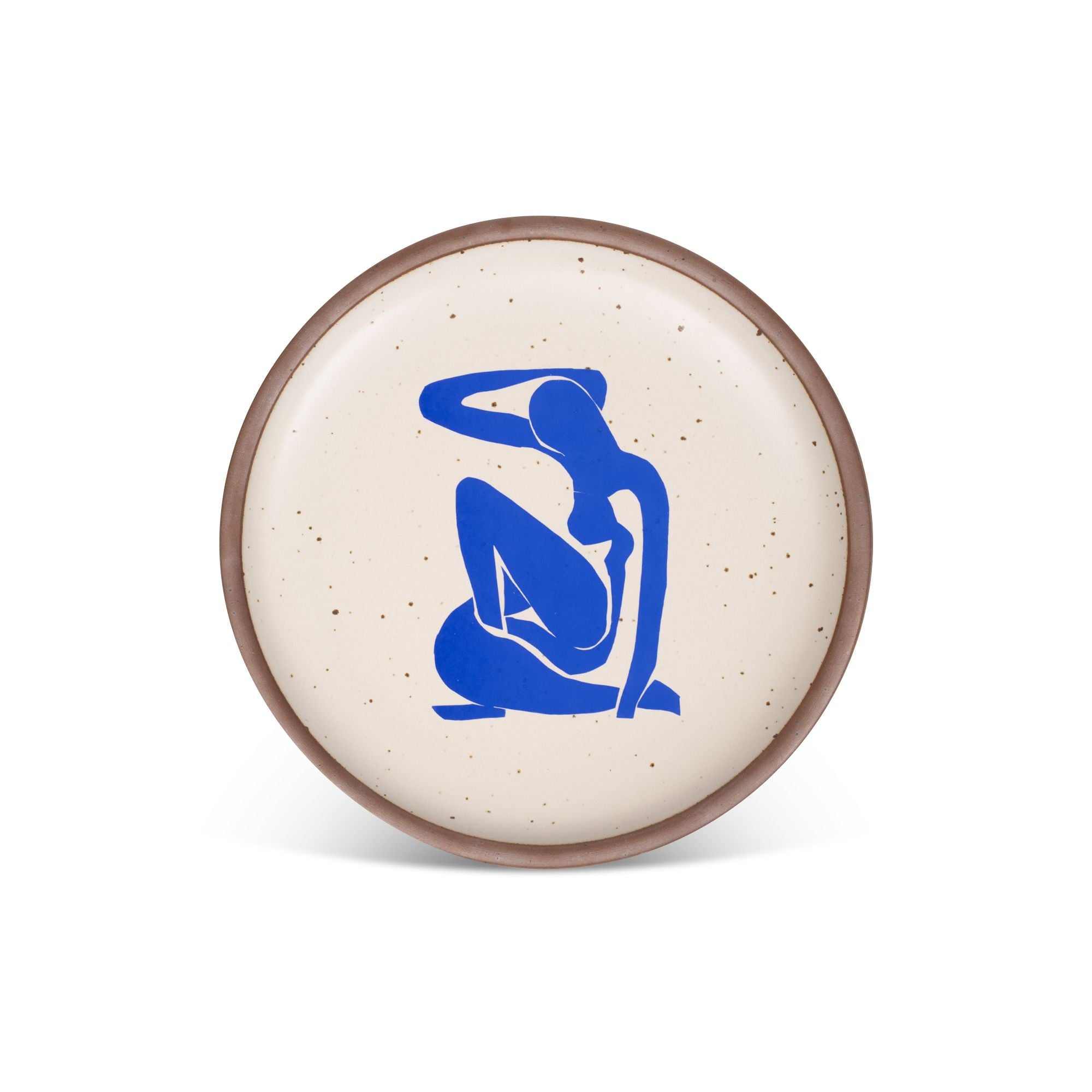 A plate featuring Nu Bleu I, by Henri Matisse, a bright blue, abstract, silhouetted female figure in a curled, seated position, with sharp cut-out edges, centered on an off-white ceramic plate with an unglazed rim.