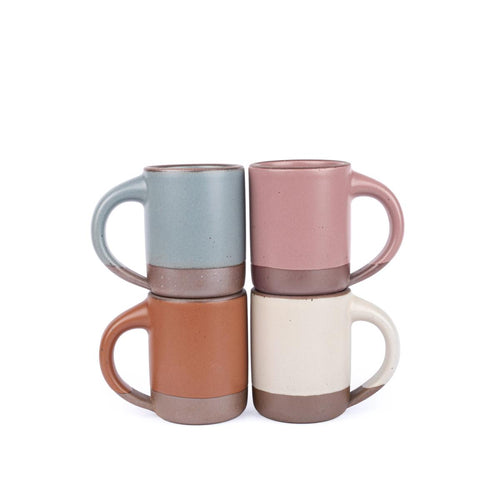 Four medium sized ceramic mugs with handles in a cool terracotta, warm off-white, blue-grey, and dusty mauve pink colors featuring iron speckles and unglazed rim