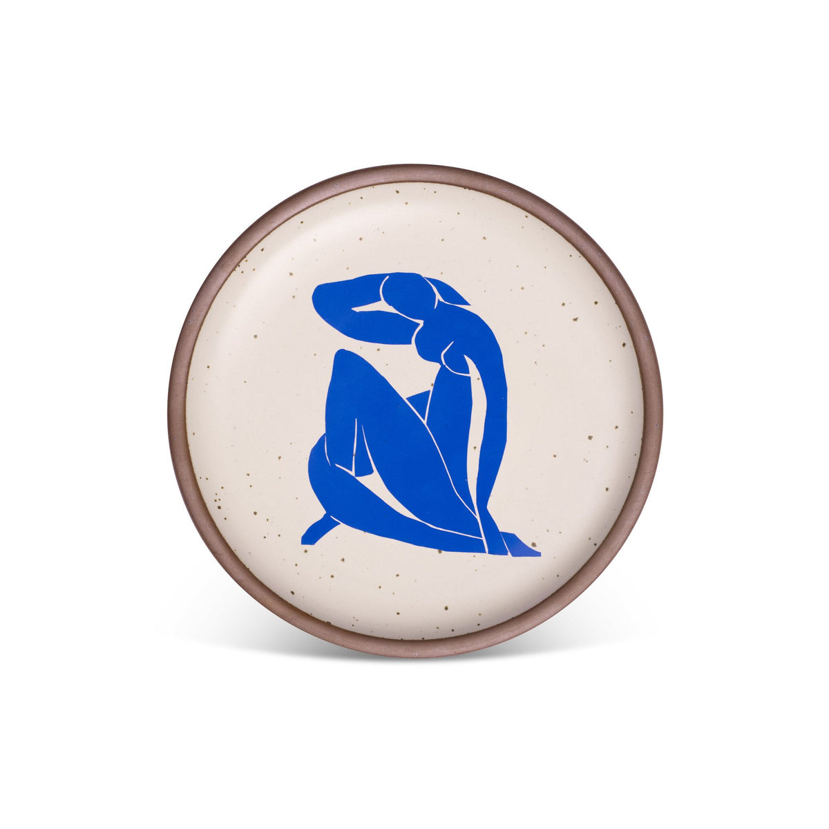 A plate featuring Nu Bleu II, by Henri Matisse, a bright blue, abstract, silhouetted female figure in a curled, seated position, with sharp cut-out edges, centered on an off-white ceramic plate with an unglazed rim.