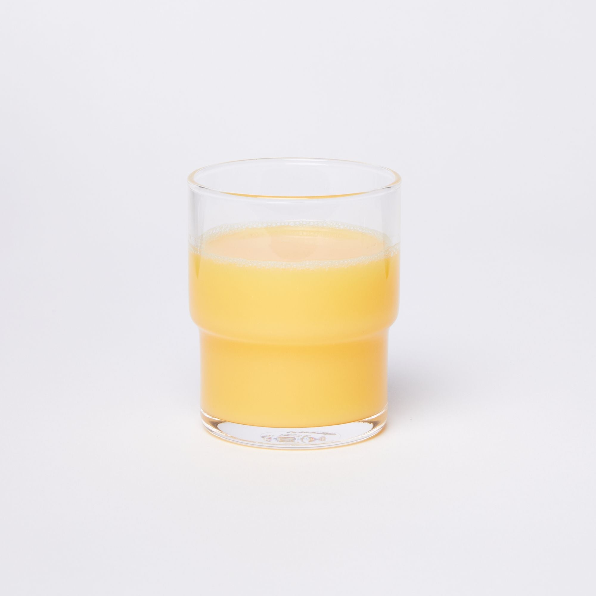 Clear cylindrical glass with a wider top half with a narrower bottom half, full of orange juice