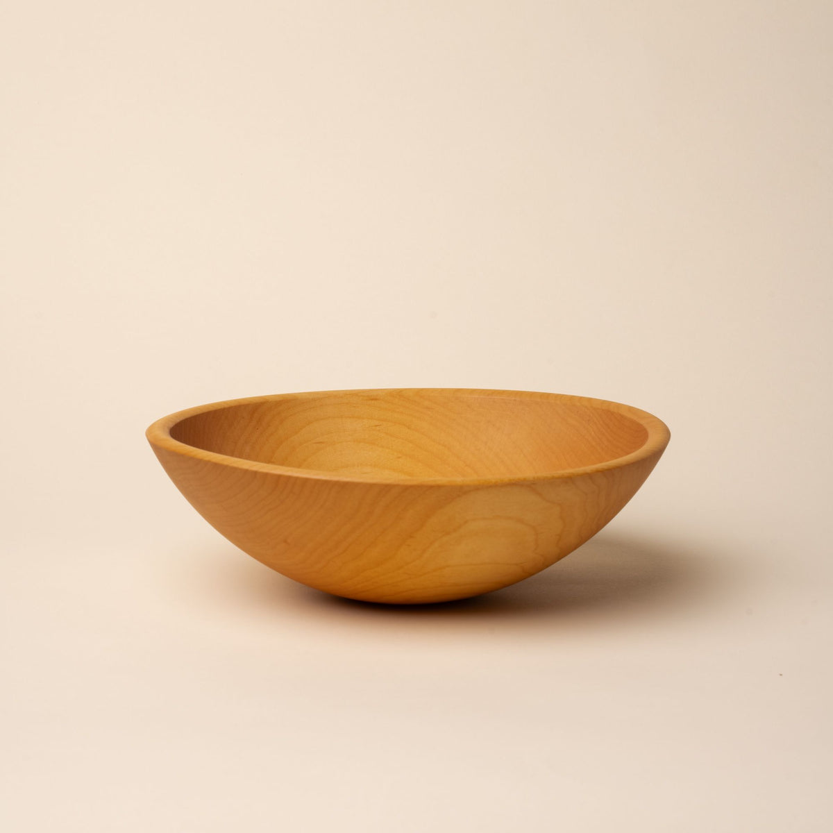 A medium sized round maple wood bowl