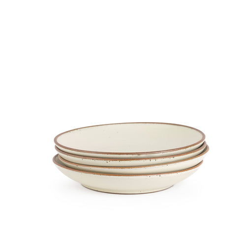 A stack of 4 large ceramic plates with a curved bowl edge in a warm, tan-toned, off-white color featuring iron speckles and an unglazed rim.