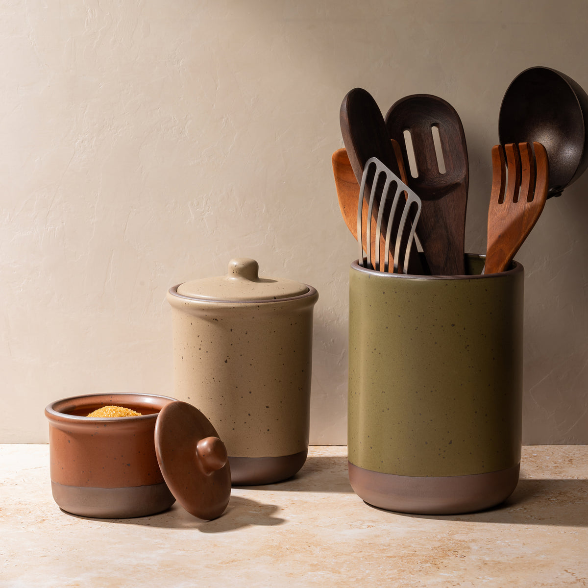 Ceramic Utensil Jar, Tall Jar, and Small Jar filled with spoons, utensils and sugar.