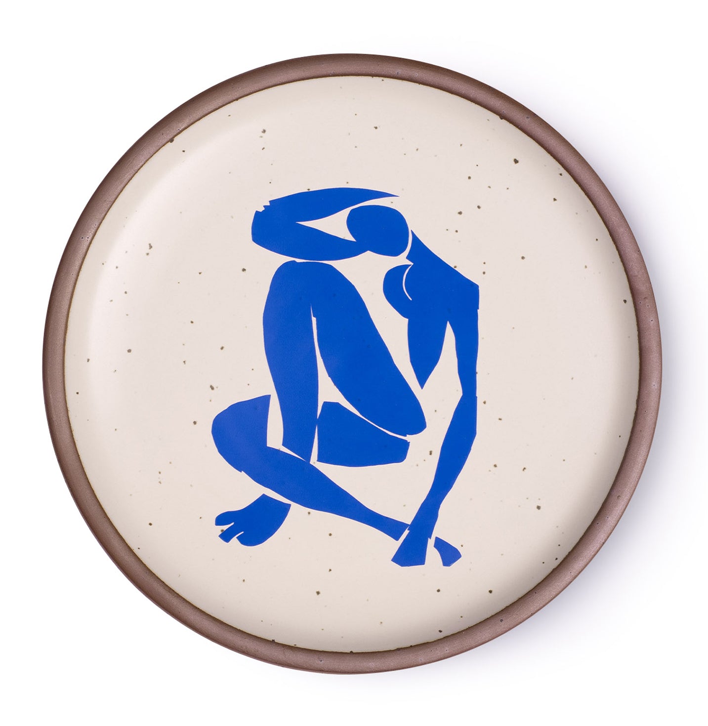 A plate featuring Nu Bleu IV, by Henri Matisse, a bright blue, abstract, silhouetted female figure in a curled, seated position, with sharp cut-out edges, centered on an off-white ceramic plate with an unglazed rim.