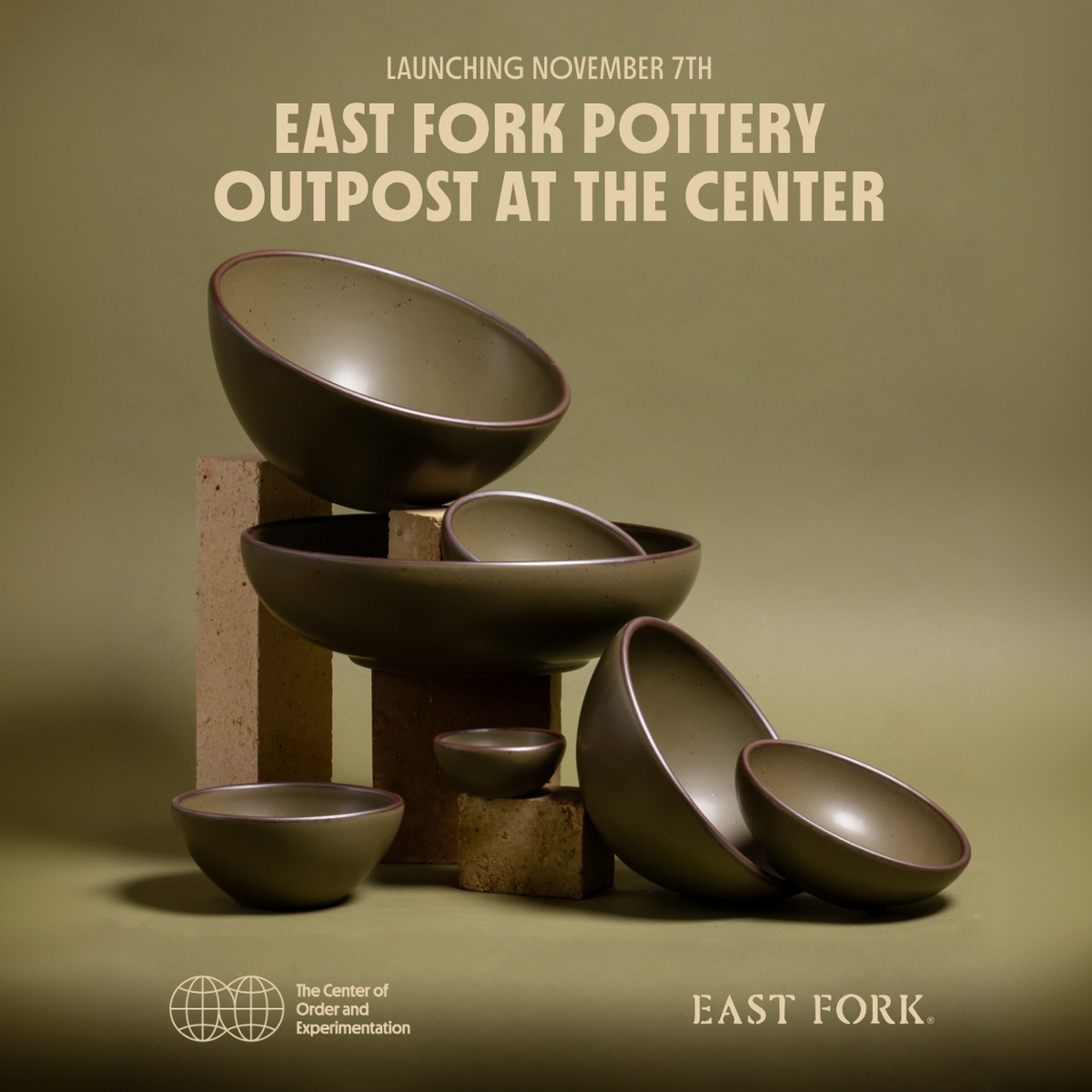 Ceramic bowls in a variety of sizes, all olive green, artfully arranged against a match backdrop with text that reads 'Launching November 7th East Fork Pottery Outpost at the Center, The Center of Order and Experimentation.'