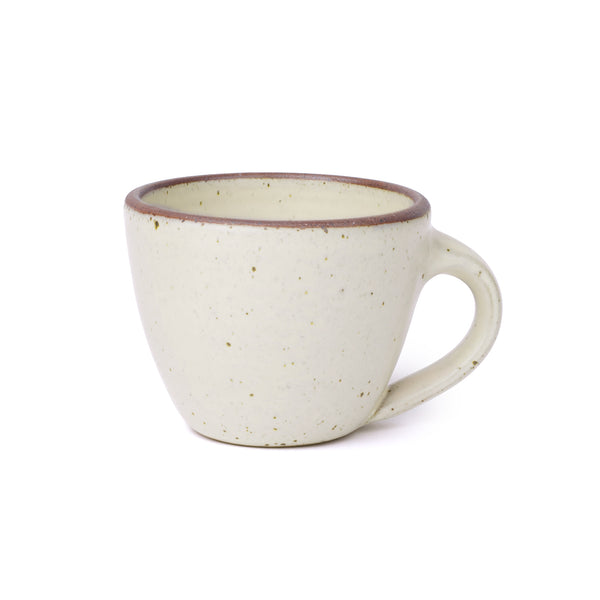 Round stoneware mug with handle, in a warm off-white with iron speckles and an unglazed rim.