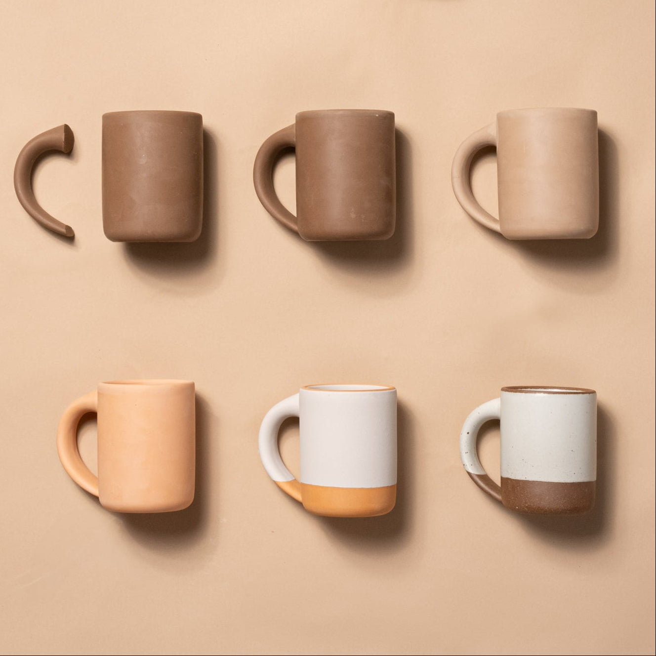 The East For Mug in a row starting as a ball of clay to bisqueware to unglaze to a final product.