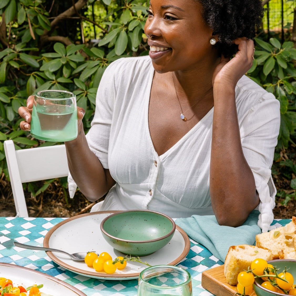 Woman enjoying a meal outdoors with a glass of water
