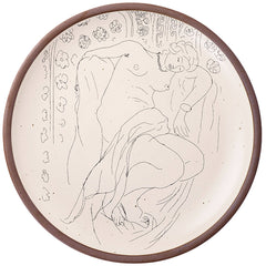 A large serving platter in a warm off-white color with unglazed rim with a black decal of the artwork, Figure endormie sur fond moucharabieh, from Henri Matisse.
