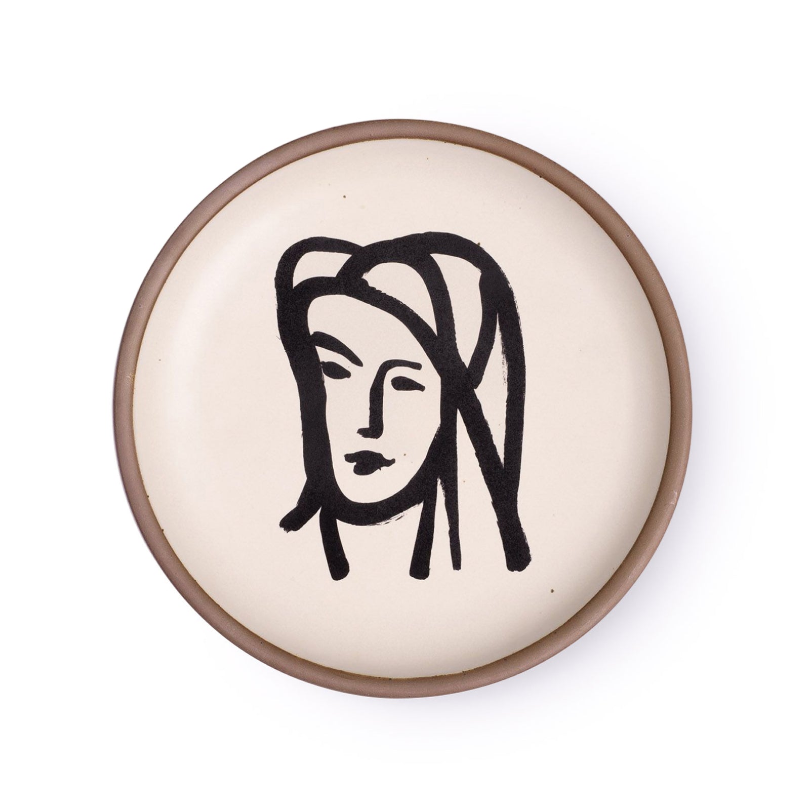 A ceramic plate featuring a decal of the artwork, Bédouine au grand voile, by Henri Matisse. A minimalist black ink decal of a woman's face wearing a large veil depicted by bold brushstrokes in an abstract, expressive style centered on an off-white ceramic plate with an unglazed rim.